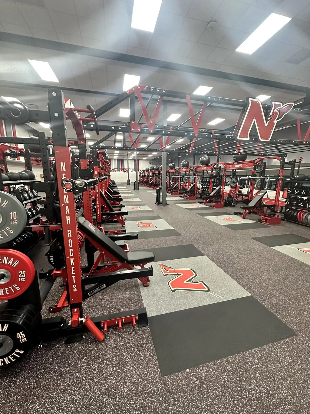 Neenah Rockets weight room with branded racks, plates and lifting platforms