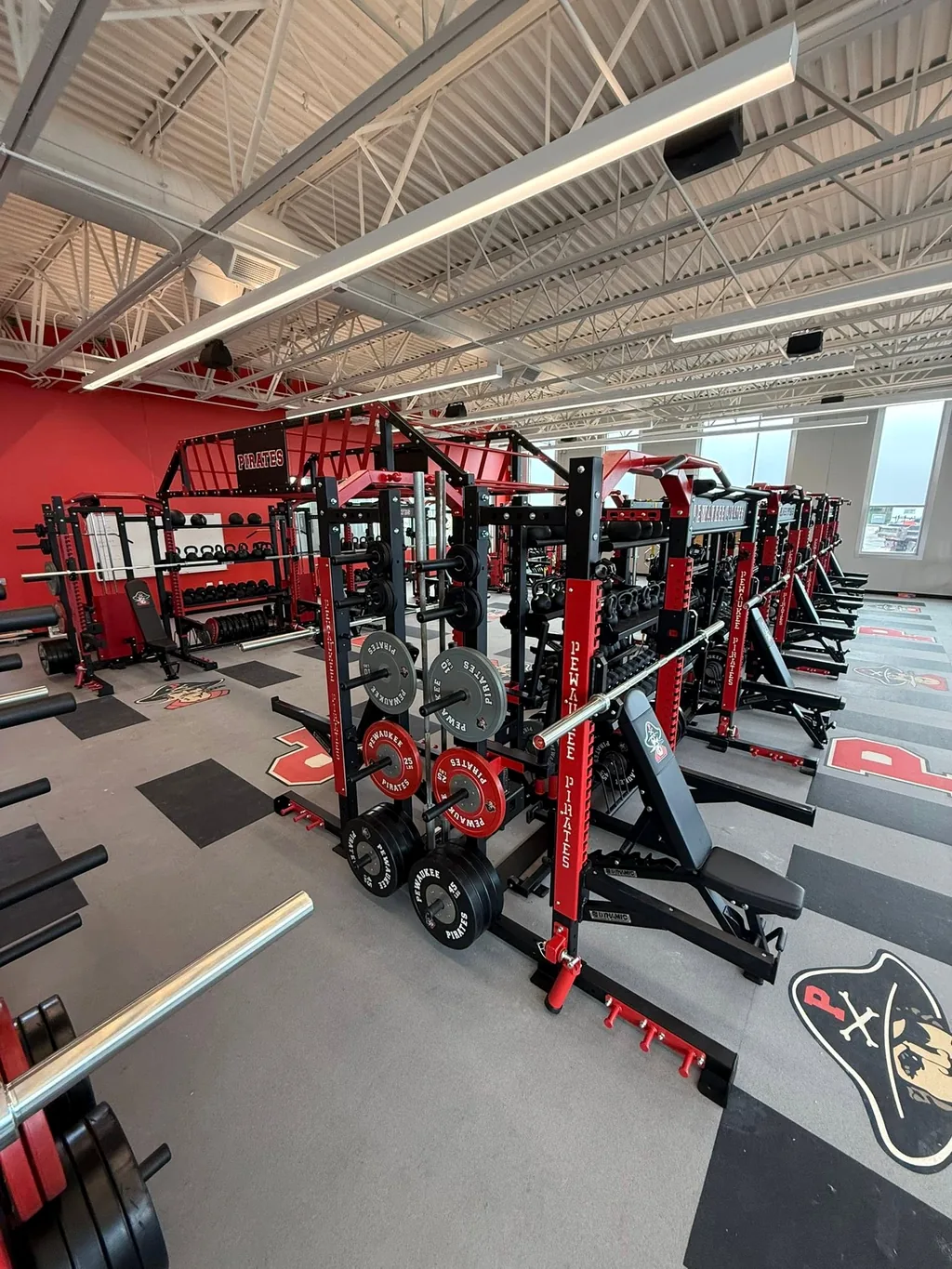 Power rack with bumper plates, barbell and adjustable bench at Pewaukee High School