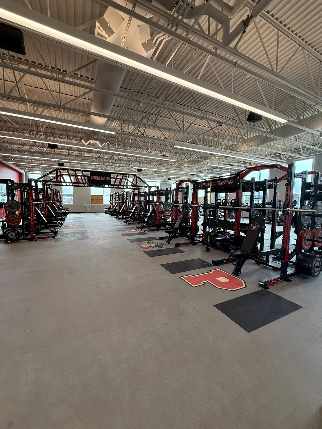Wide view of the Pewaukee High School training floor with racks along both walls